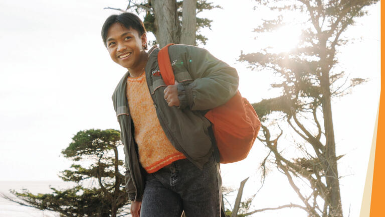 USF student smiling and walking with orange backpack