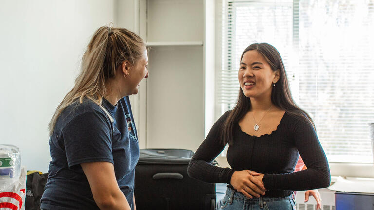 Two USF students chatting in a dorm room