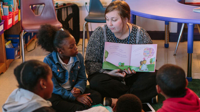USF student reading to children in a classroom