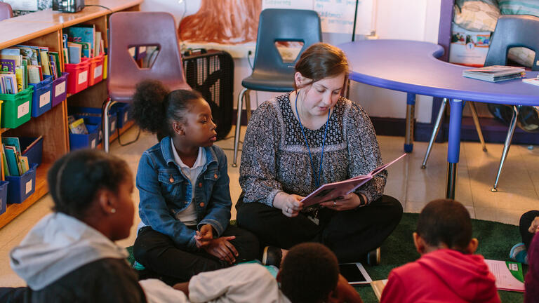 teacher reads to elementary school students in class