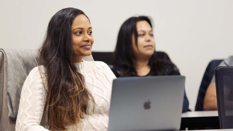 Students on laptops engaged in class