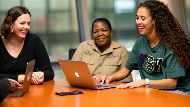 Three USF students working together at a table