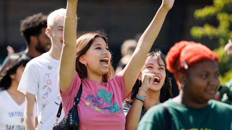 student raises hands in the air