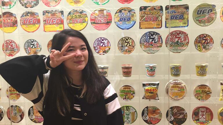 Amanda Tsuhako posing in front of instant ramen bowls