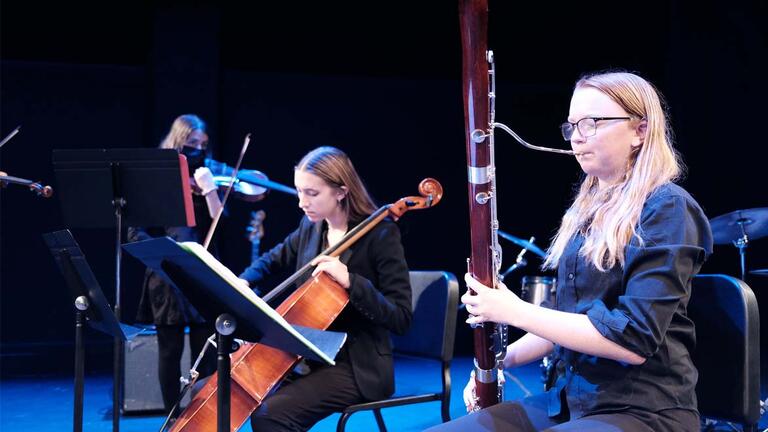 women play classical instruments during a performance