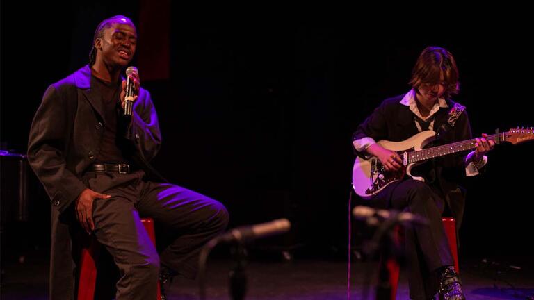 a singer and guitar player rock out durning a performance