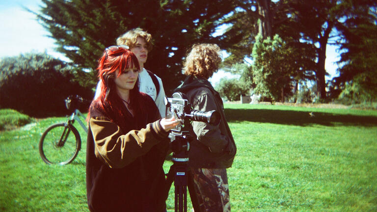 USF students filming in the grass on campus