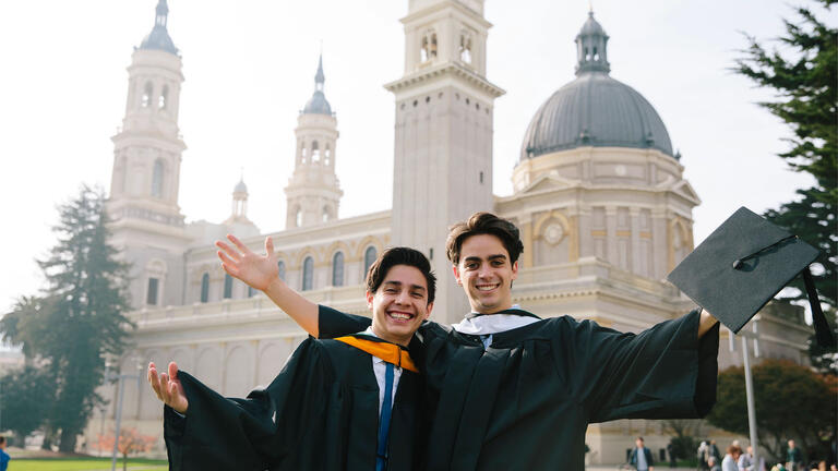Two USF students posing in front of St. Ignatius