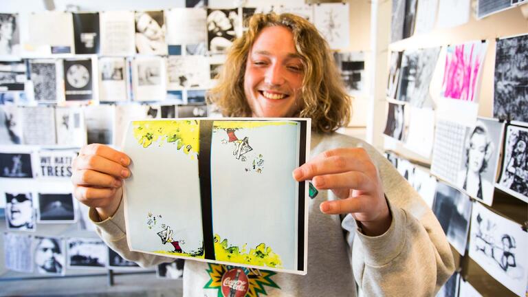 Student holding an art piece