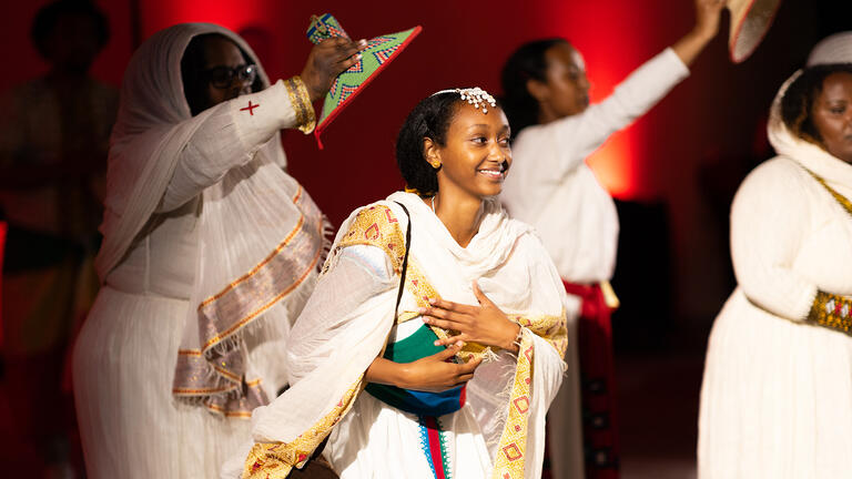 students performing a dance on campus