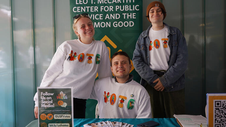 Students at a table encourage voter registration