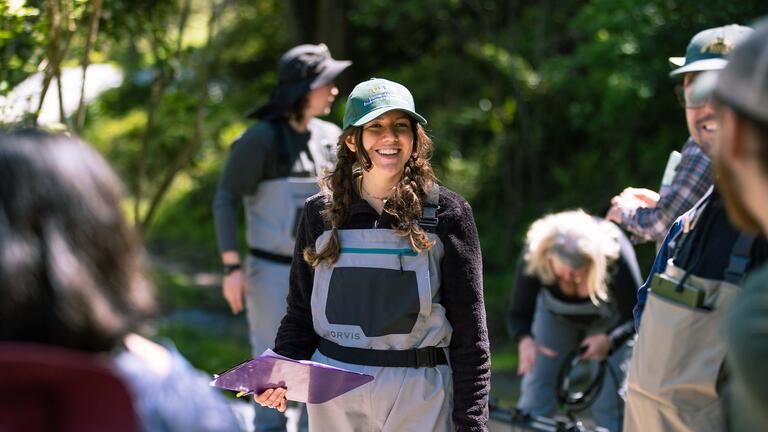 Student smiling outdoors with other students around