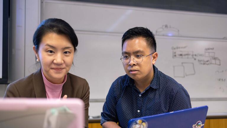 Faculty and student working on their computers