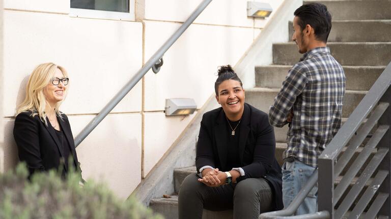 Three people talking on stairs