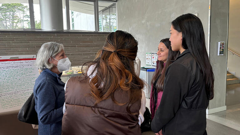 Students talking to another person in a mask