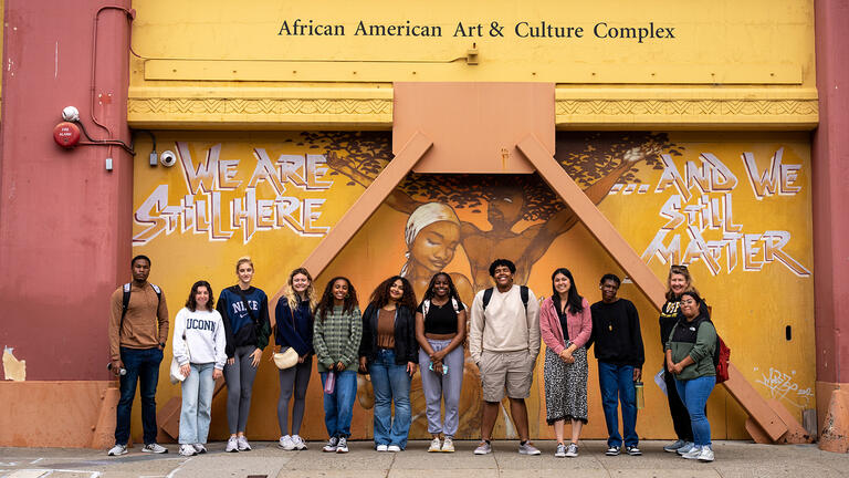 group of students standing in front of the African American Arts & Culture Center 