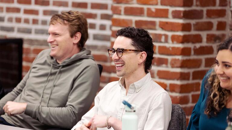 Three school of management students smiling in class