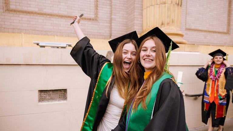 Two graduates smiling