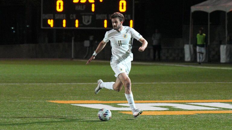 student athlete runs with soccer ball