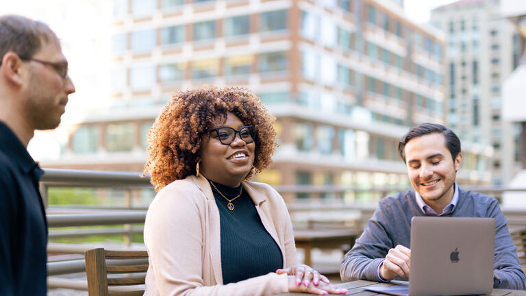 student smiling with others at the downtown campus