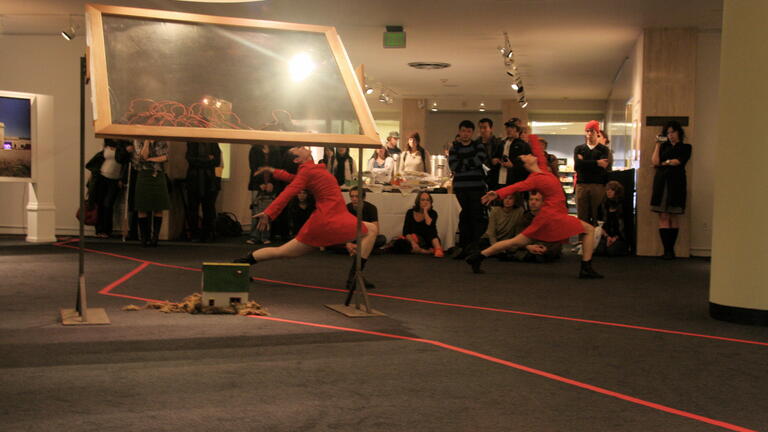 Three performers in red dresses in mid-motion