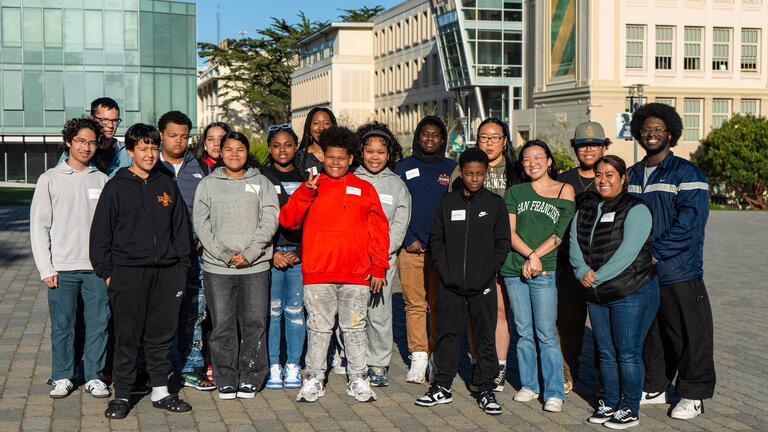 usf students stand with mentees on campus