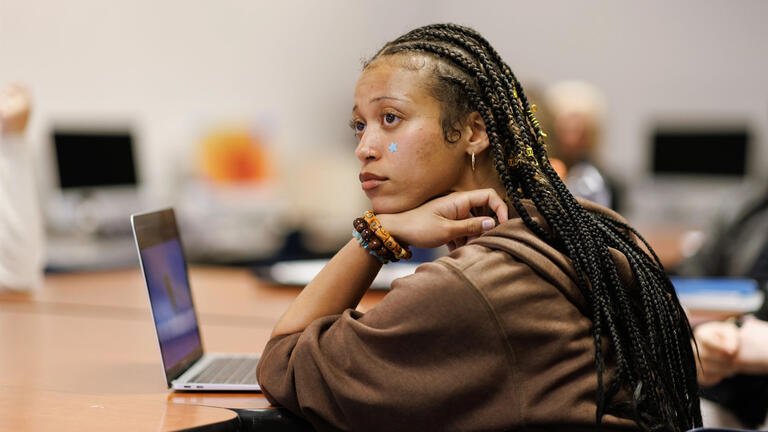 student in classroom listing to lecture