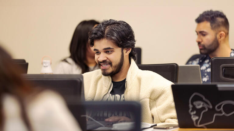 USF student working on laptop in class