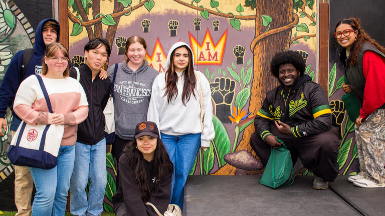 group of mccarthy center equity interns in front of mural