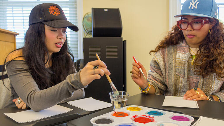 two students paint together