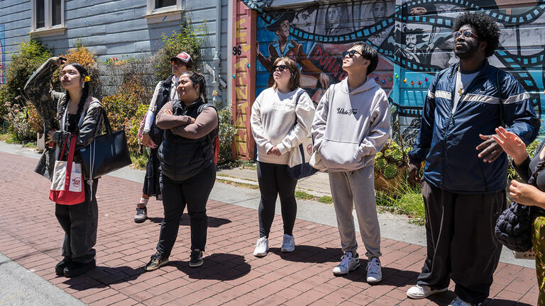 group of equity interns stand together while looking at murals