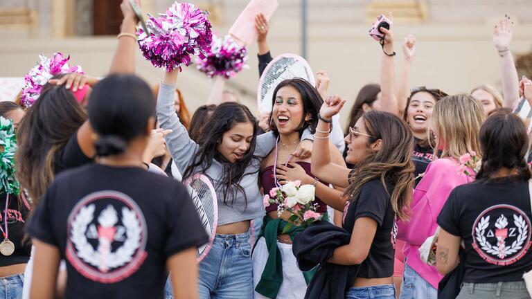 Group of USF students cheering at bid day for greek life
