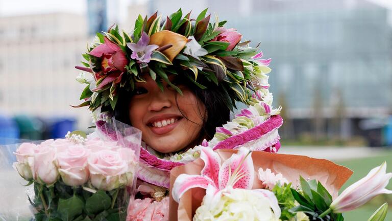 graduating student holding flowers