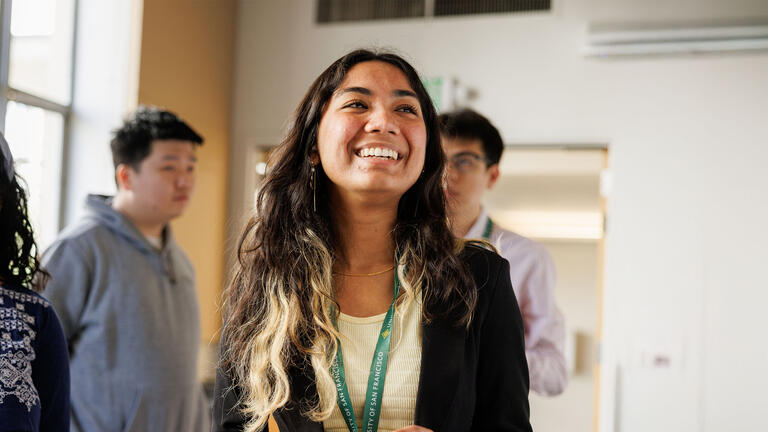 USF student wearing yellow shirt and a blazer smiling