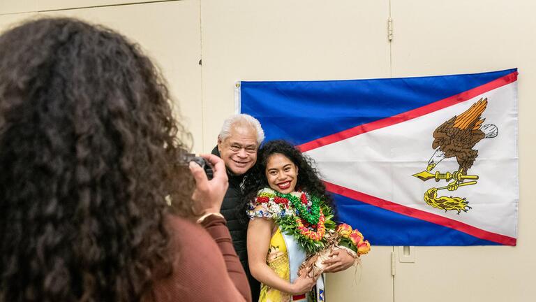 student smiles with parent at commencement
