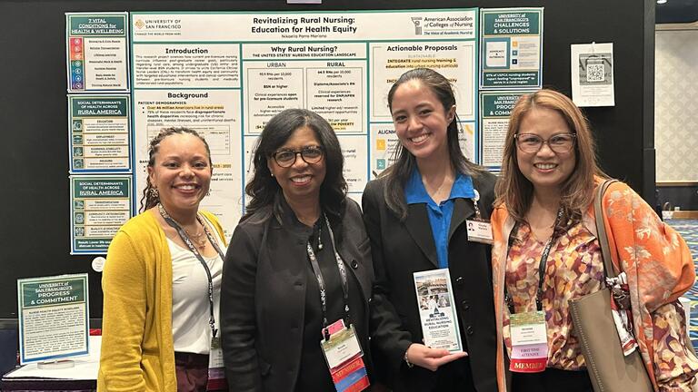 Student with three other people in front of a research poster