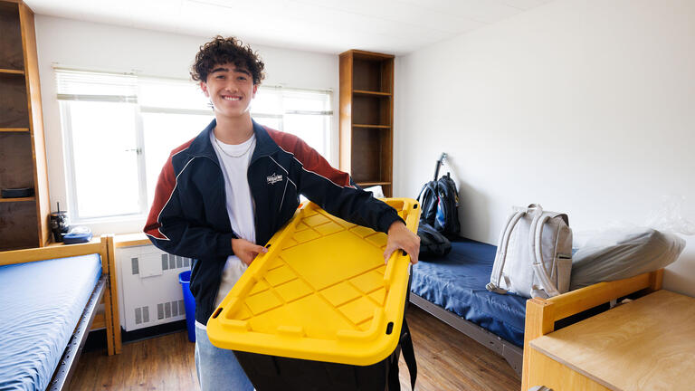 Student unpacking in new residence hall room