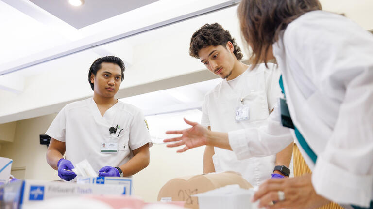 students in scrubs practice nursing skills