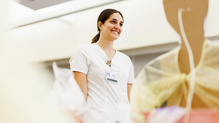 nursing student smiles in sim lab