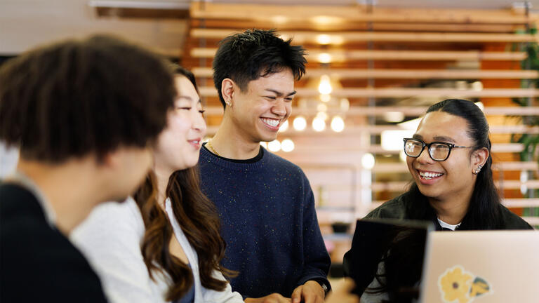 USF students sitting in cafeteria, chatting and smiling