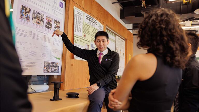 Person presenting poster to people