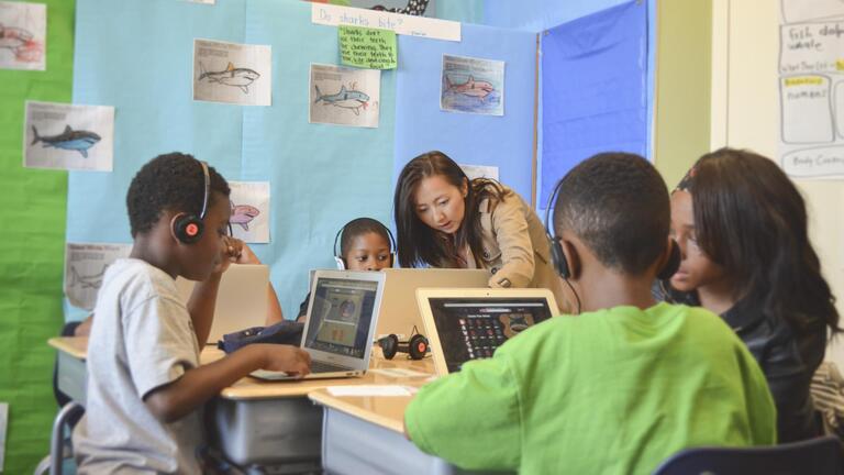 Teacher helping students in computer lab