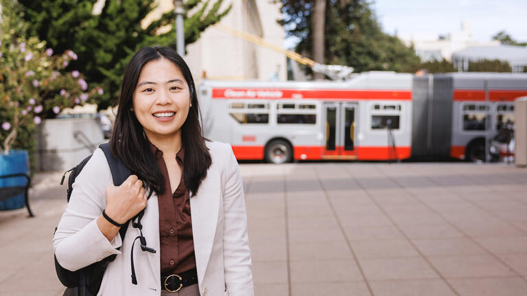student stands in front of muni