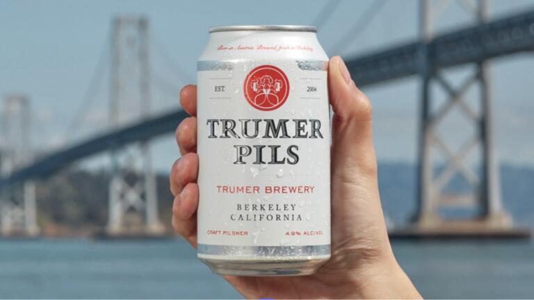 Hand holding a Trumer beer
