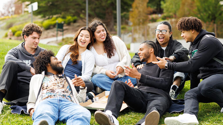 group of students hanging out on grass outside