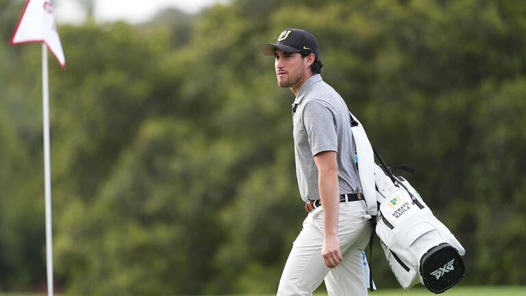 student golfer walks on grass
