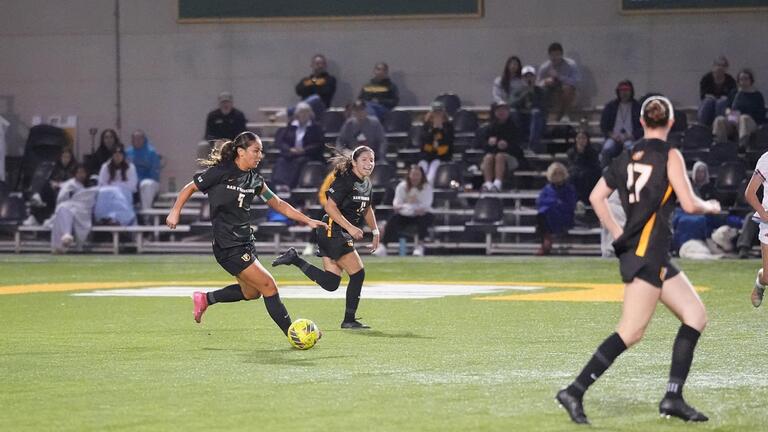 students run down the soccer field