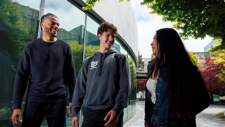 Three students walking on campus