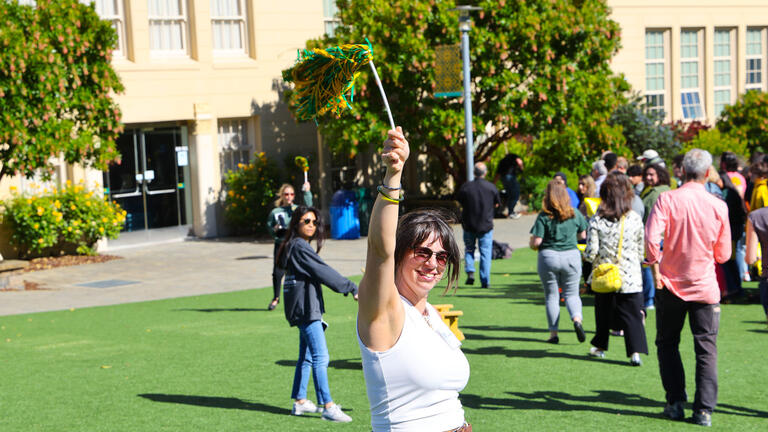 person waves pom pom during bbq event