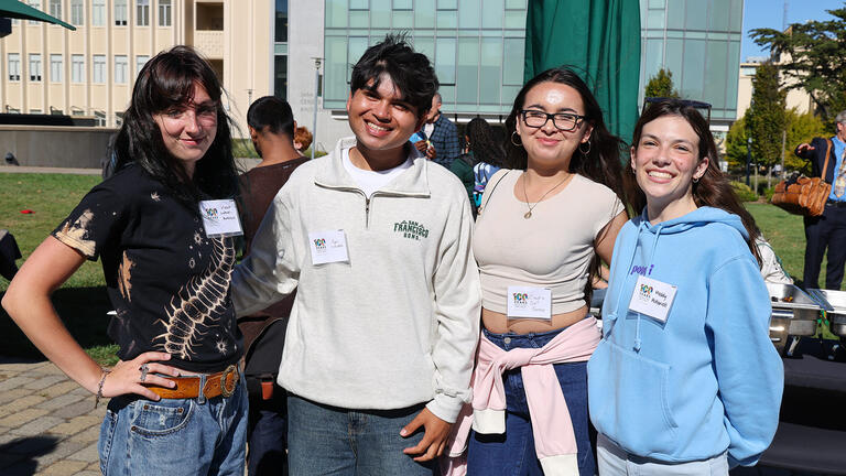 students smile together outside during the centennial bbq